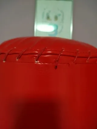 Saco de boxeo de pie rojo con guantes y cuerda.