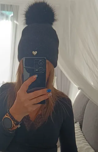 Gorro negro con pompón Lleva hilos plateados