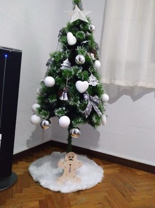 Árbol de Navidad con adornos y falda.