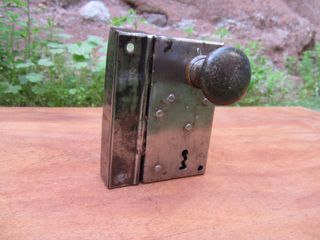 Cerradura antigua con pomo y maneta verdes.