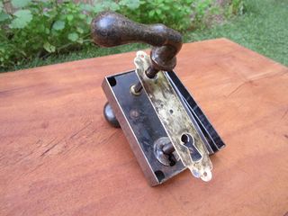 Cerradura antigua con pomo y maneta verdes.