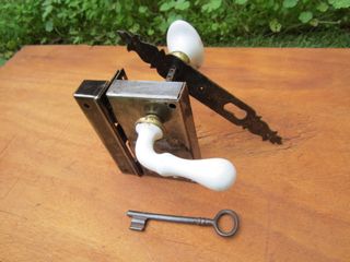 Cerradura antigua con su llave, pomo cerámico.