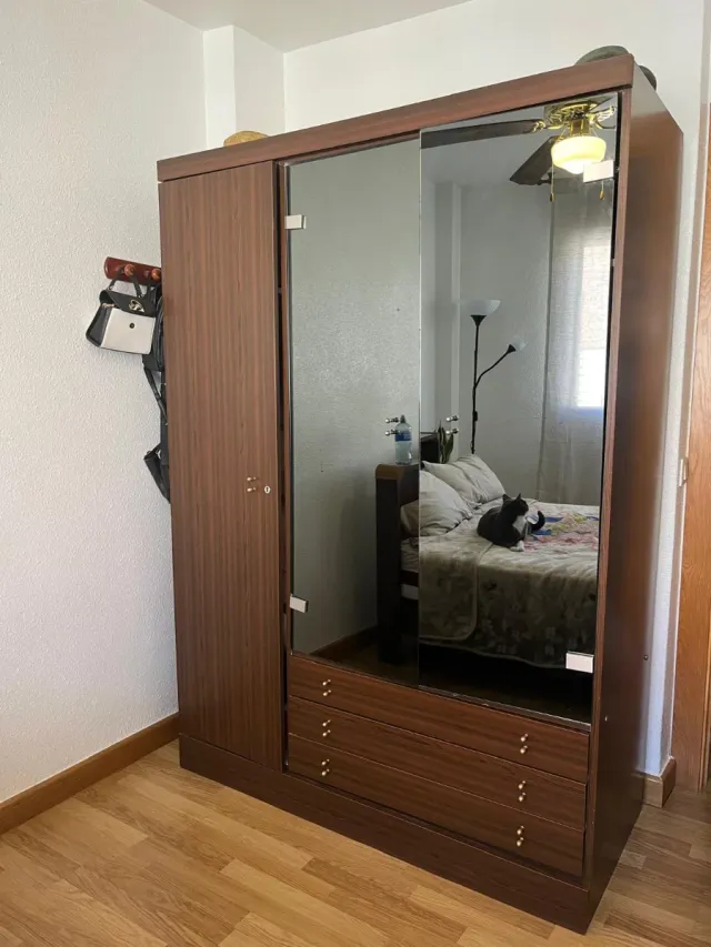 Armario de madera con puertas correderas y cajones