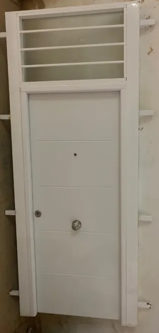 Puerta blanca con reja superior