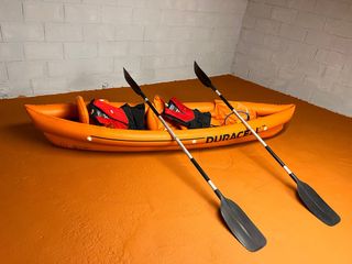 Kayak hinchable naranja con remos y chalecos
