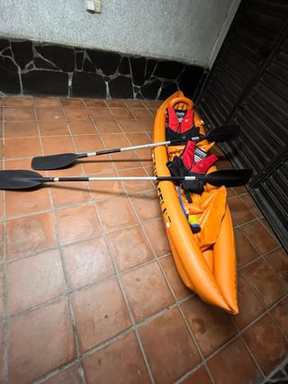 Kayak hinchable naranja con remos y chalecos