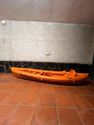 Kayak hinchable naranja con remos y chalecos