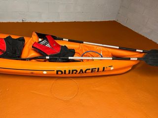 Kayak hinchable naranja con remos y chalecos