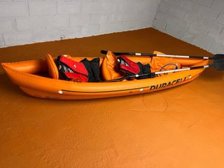 Kayak hinchable naranja con remos y chalecos