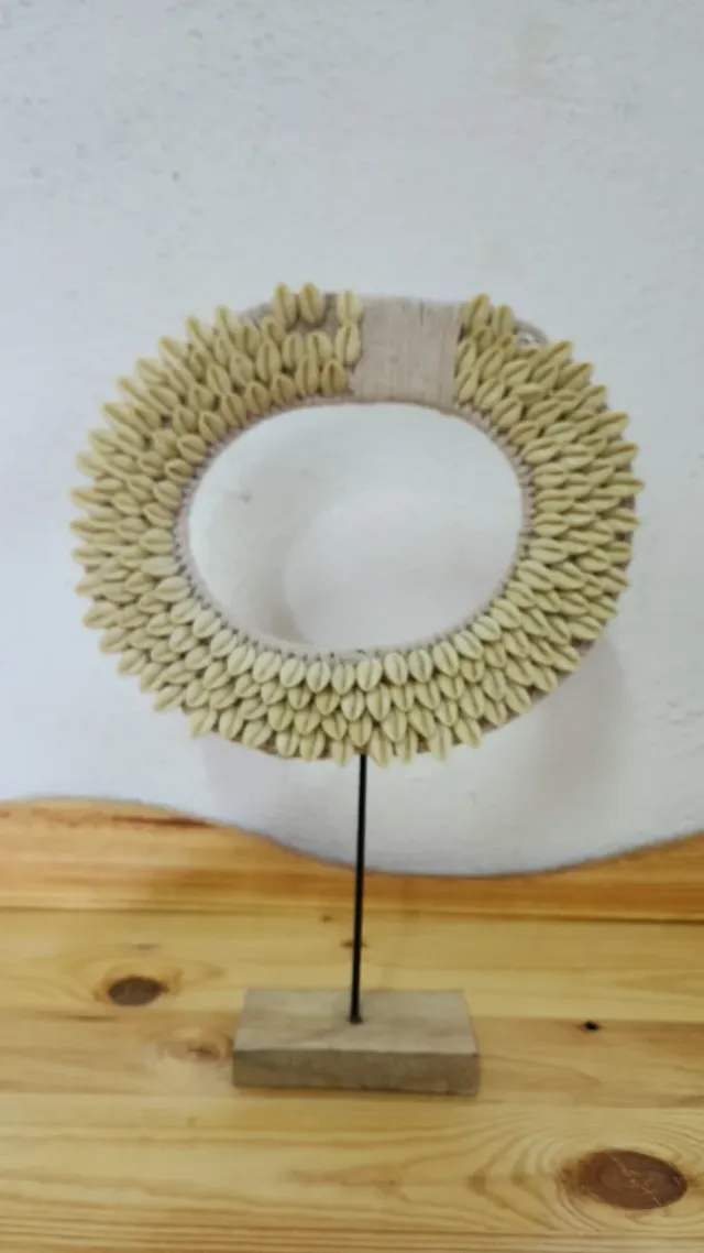 Figura decorativa étnica con conchas cauri