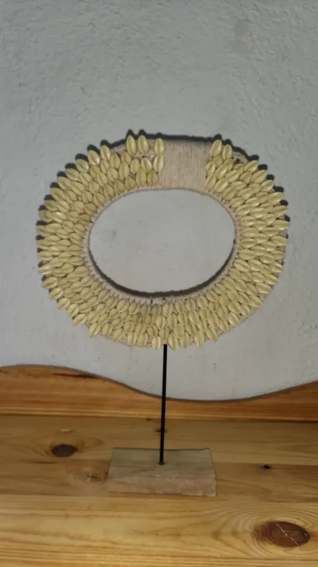 Figura decorativa étnica con conchas cauri