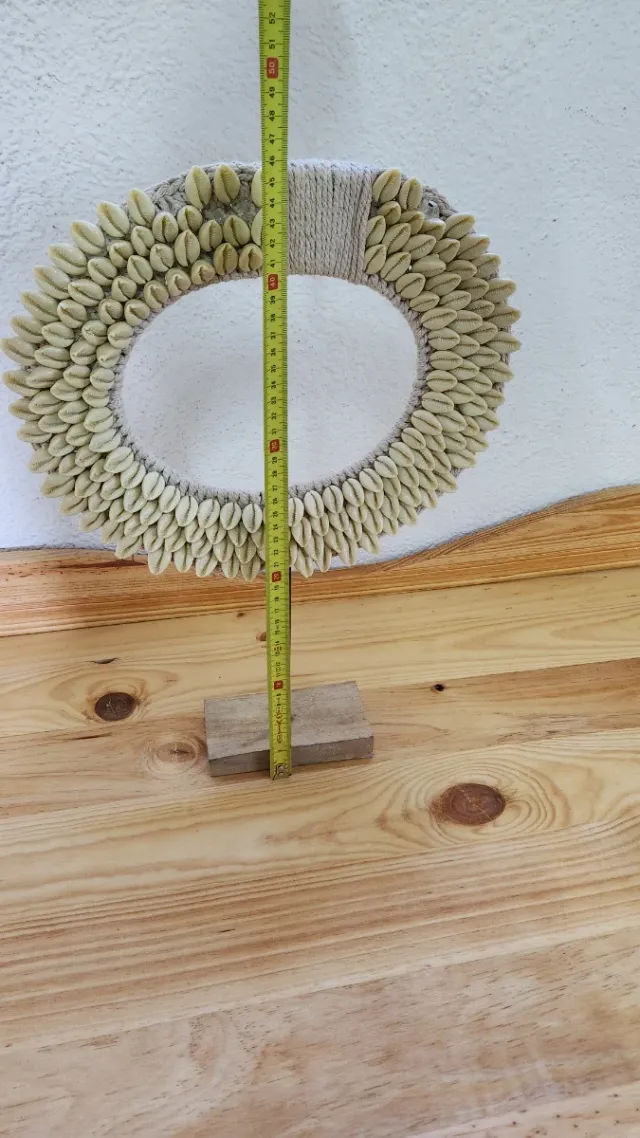 Figura decorativa étnica con conchas cauri