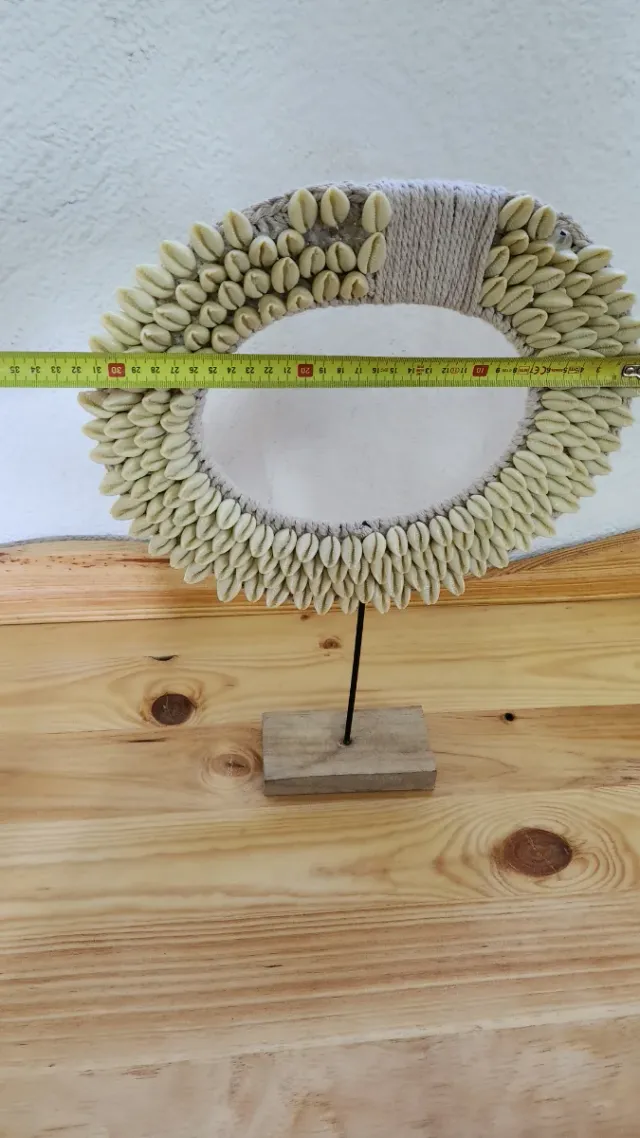 Figura decorativa étnica con conchas cauri