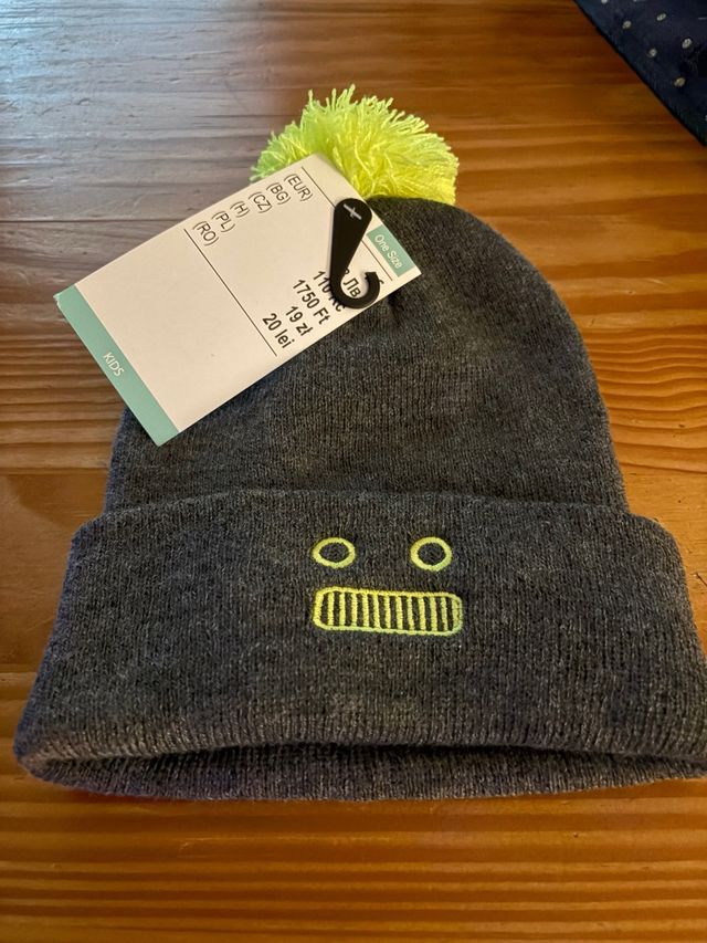 Gorro infantil gris con pompón amarillo