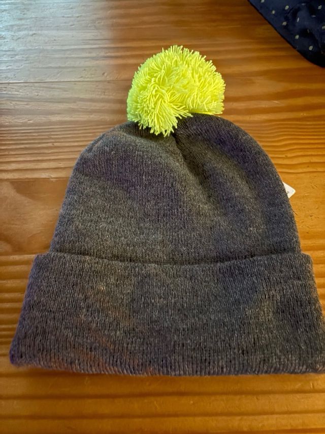 Gorro infantil gris con pompón amarillo