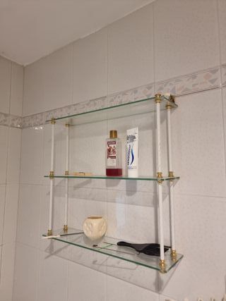 Estantería de cristal con soportes dorados