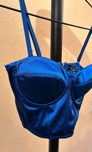 Corsé azul satinado con tirantes ajustables.