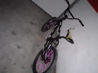 Bicicleta BMX con ruedas moradas.