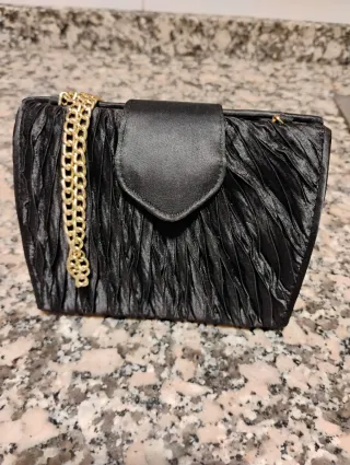 Bolso de mano negro con cadena dorada