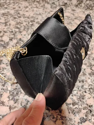 Bolso de mano negro con cadena dorada