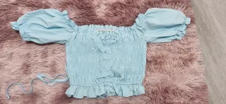 Top azul con volantes y lazada