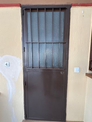 Puerta de hierro con ventana abatible