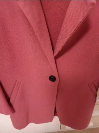 Abrigo Stradivarius rosa y plumas naranja.