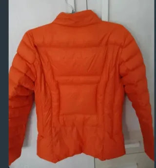 Abrigo Stradivarius rosa y plumas naranja.