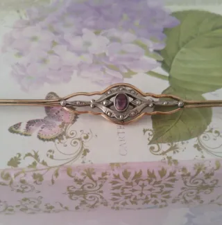 Broche antiguo con piedra morada y detalles dorado