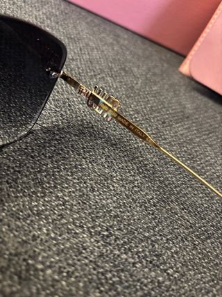 Gafas de sol Miu Miu negras y doradas