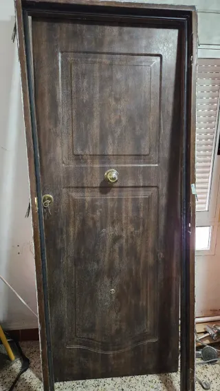 Puerta de entrada marrón con pomo y cerradura