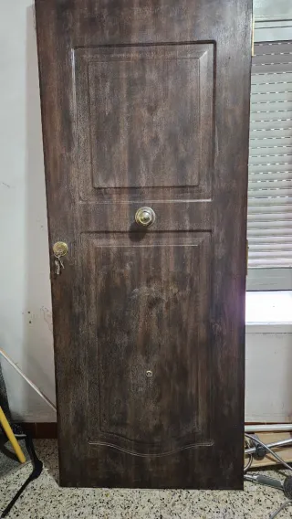 Puerta de entrada marrón con pomo y cerradura