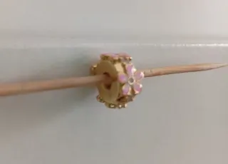 Clip dorado con margaritas rosas.