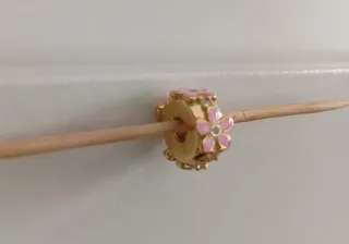 Clip dorado con margaritas rosas.