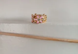 Clip dorado con margaritas rosas.