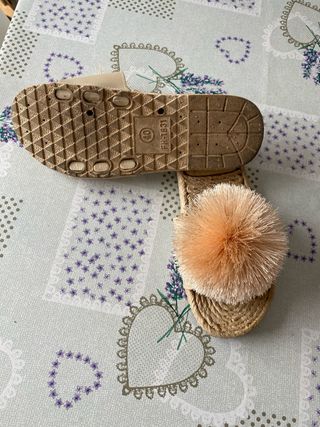 Sandalias planas beige y naranja con pompón