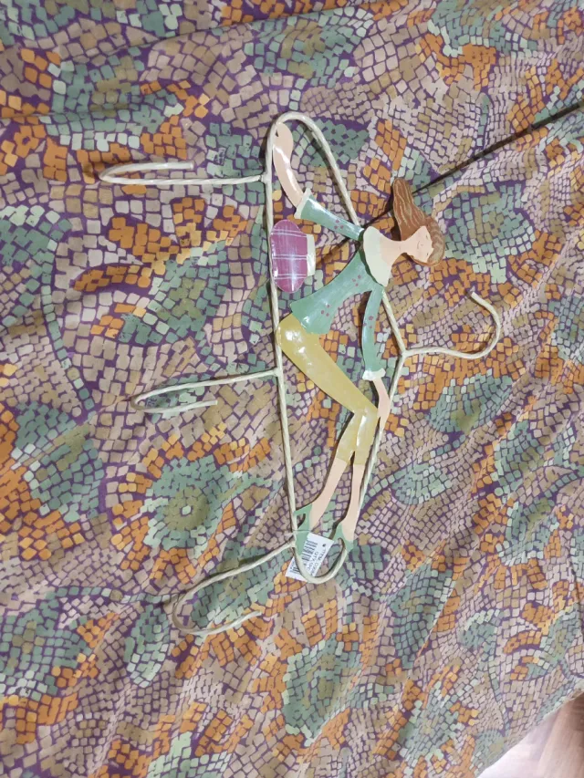 Colgador de metal con figura de mujer