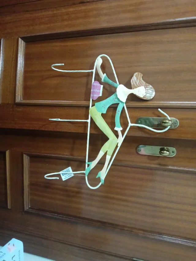 Colgador de metal con figura de mujer