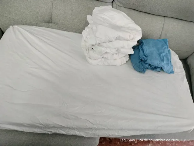 Sábanas bajeras cuna blancas y azules.