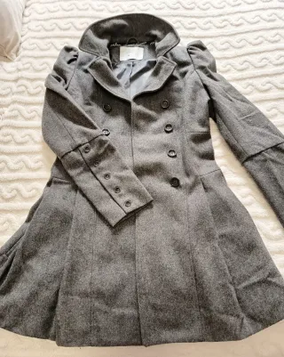 Abrigo gris elegante hombro abullonado.