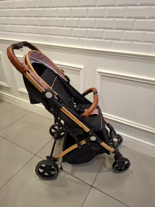 Carro de bebé rosa y dorado