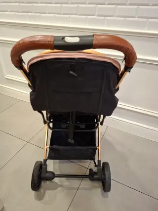 Carro de bebé rosa y dorado