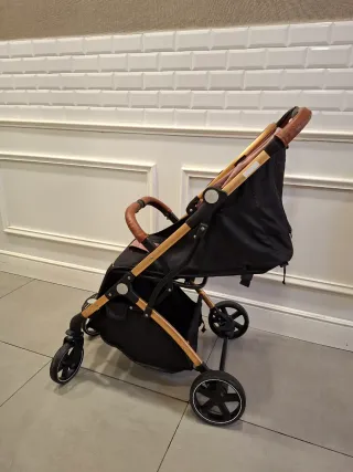 Carro de bebé rosa y dorado