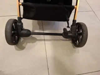 Carro de bebé rosa y dorado