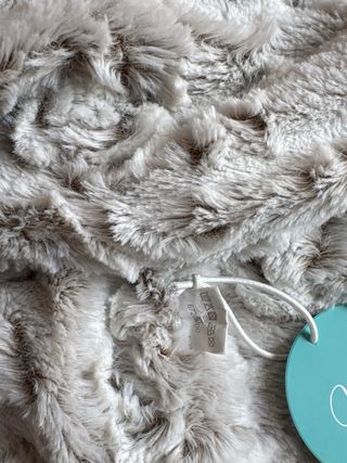 Bufanda de pelo gris con etiquetas