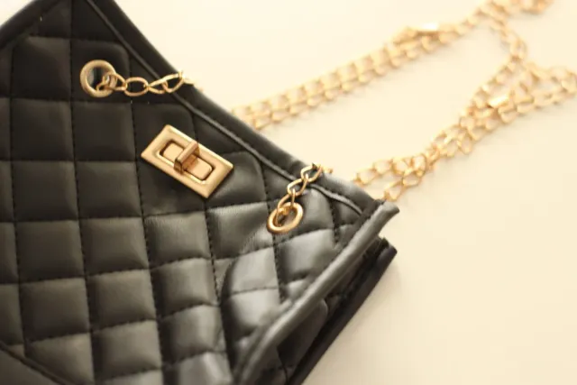 Bolso negro con detalles dorados.