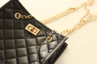 Bolso negro con detalles dorados.