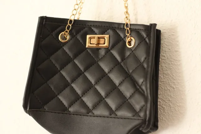 Bolso negro con detalles dorados.