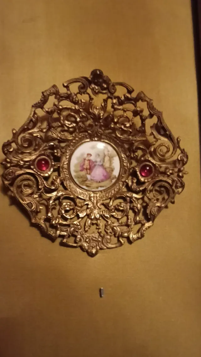 Cuadro dorado con porcelana y piedras rojas