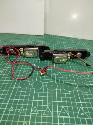 Pareja de altavoces negros con cables rojos